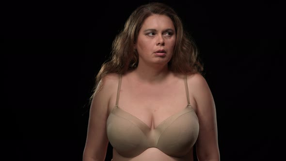 Medium Shot Caucasian Plus Size Woman in Bra Looking Around with Scared Facial Expression Covering alt