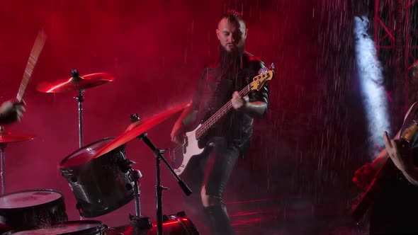 Camera Slides Over a Group of Rock Musicians Who Play Their Instruments with Crazy Emotions in a alt