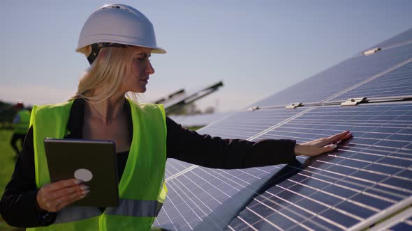 Female Ecological Engineer Uses Digital Tablet and Collects Efficient Information About Solar Panels alt