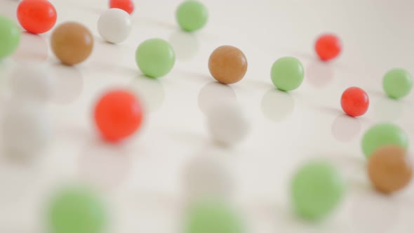 Various color bonbons on the white shiny and reflective background 4K 3840X2160 UHD video - Mixed co