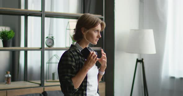 Young Woman Is Putting Wireless Headset On, Using Gadget To Listen Music alt