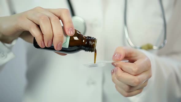 Pediatrician curing ill child with cough syrup, treatment at children's clinic alt