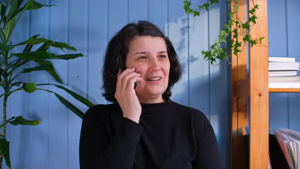 Happy Middle Aged Woman Talking on Smartphone with Friends alt