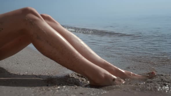 Tanned Woman Legs Smeared Beach Sand on Sunlight Closeup alt