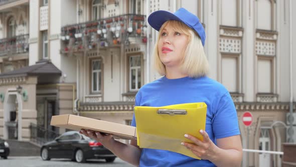 Friendly Pizza Delivery Woman Smiling To the Camera While Working in the City