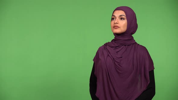 A Young Beautiful Muslim Woman Looks Around  Green Screen Background