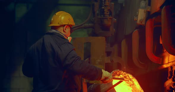 The worker pours in the form of hot metal. Metalworks