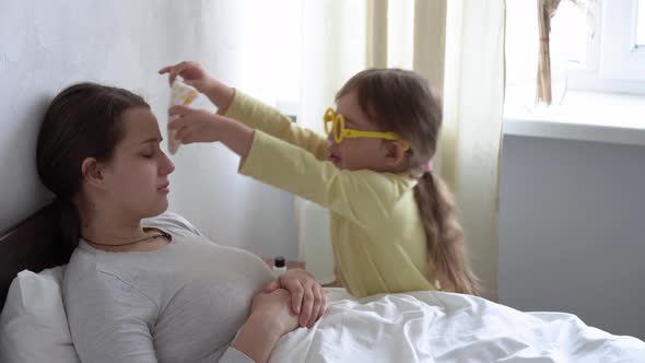 Little Girl Wearing Uniform Playing Doctor Nurse with Young Mum Nanny in Bedroom Checking Mother