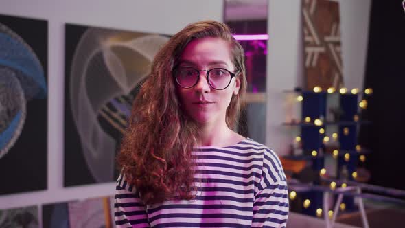 A Young Woman is Smiling and Looking at the Camera alt