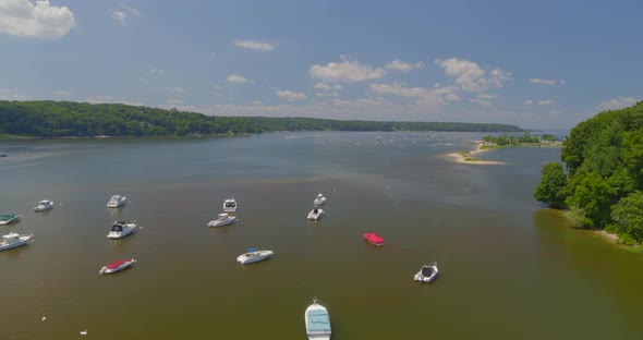 Flying Over Anchored Boats on Harbor Near a Forest on a Sunny Day alt