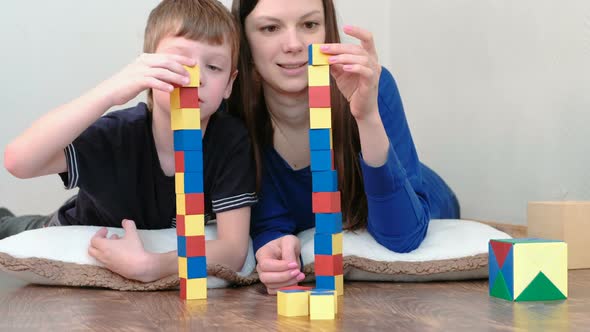 Building a Towers From Blocks. Mom and Son Playing Together with Wooden Blocks