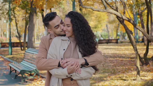 Hispanic Family Hugging Standing in Autumn Park Young Couple Smiling Talking Romantic Date Outdoors alt