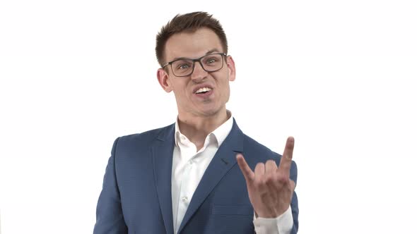 Carefree Funny Businessman in Blue Suit and Glasses Smiling Showing Heavy Metal Sign Listening to alt