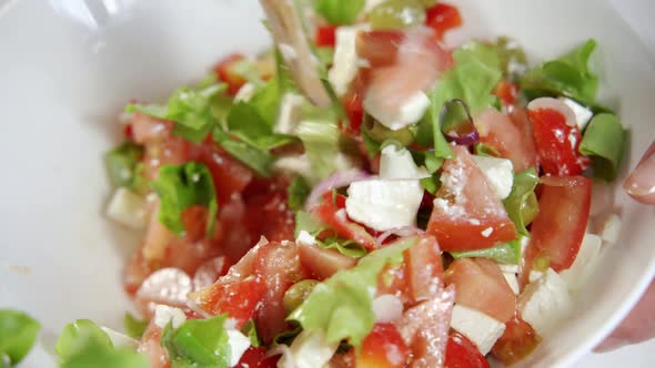 A Wooden Spatula Mixes a Fresh Tomato and Feta Salad