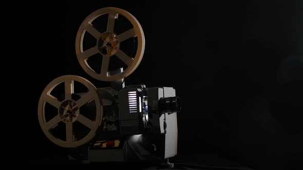 Working Projector Side View Studio. Smoke on Black Background alt