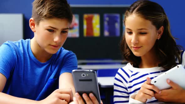 Students using digital tablet and mobile phone in classroom alt