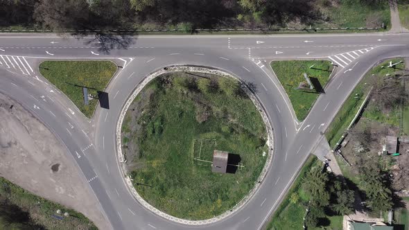 Roundabout traffic of cars and trucks on the circle ring road aerial top view. alt