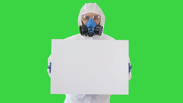 Lab Scientist in Safety Suit Holding Empty White Board on a Green Screen, Chroma Key alt