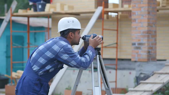 Surveyor Performs Measuring Operations on the Level and the Theodolite