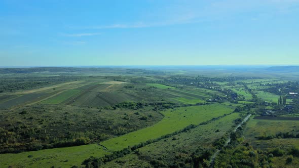 Drone Aerial View of Autumn Fields with Countryside Farmland Huts Around the Little Village alt