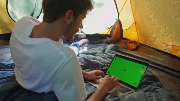 Slow Motion Freelance Working at a Laptop While Lying in a Tent Typing Text and Remote Working in alt