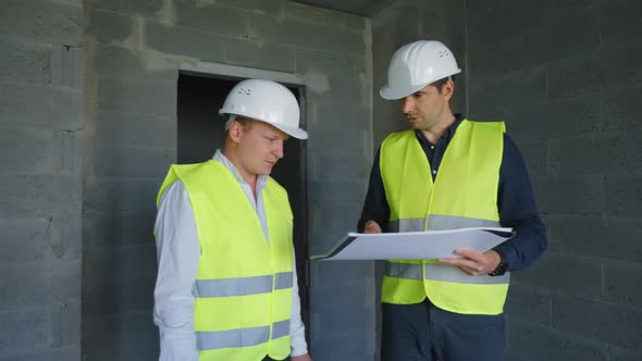 Architect and Foreman Discussing Project at Construction Site alt