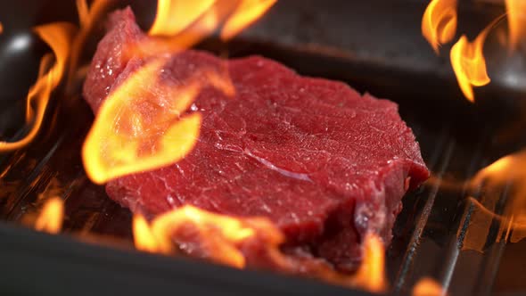 Super Slowmotion Footage of Throwing Fresh Beef Meat and Seasoning on Ignited Pan, 1000Fps  alt