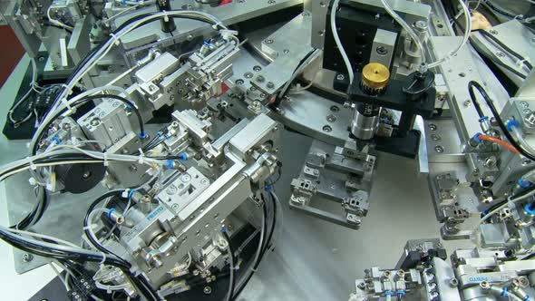 Advanced industrial production line for small parts, robotic arms working alt