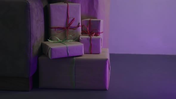 Orbit Shot of Christmas Gifts Under Spruce Indoor with Neon Light
