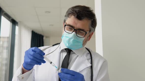 Doctor Holds a Syringe and Vaccine Bottle at the Hospital alt