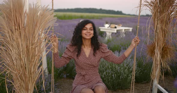 Young Indian Woman Sitting on a Decorated Swing in Lavender Field alt