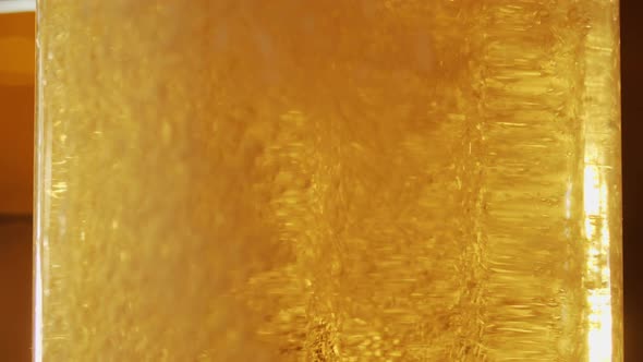 Close-up of fine bubbles rising in the glass of fresh beer.