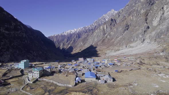 Flying over village with blue roofs in Langtang Nepal, in the mountains alt