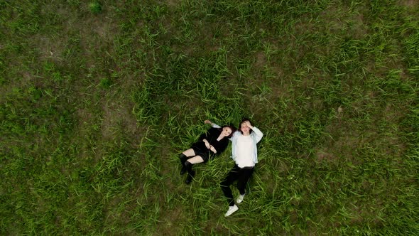 A Young Man and a Woman are Lying on the Lawn