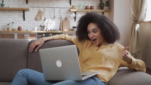 Surprised African American Lady Is Very Surprised Looking at Her Laptop. Relaxing at Home. alt
