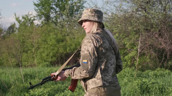 Ukrainian Female Soldier Armed with an Assault Rifle Patrols a Combat Zone