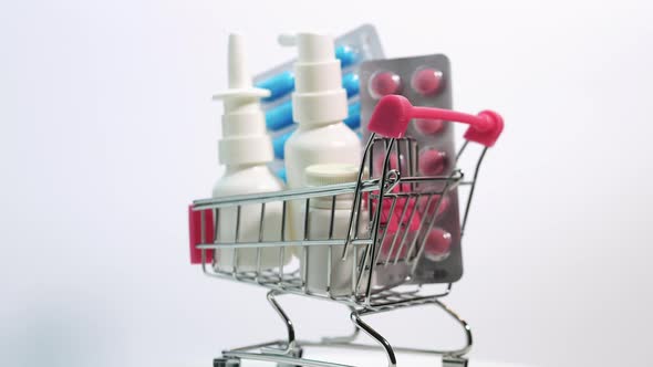 Medicines In A Trolley From A Supermarket On A White Background Rotate, Nasal Spray With Pills