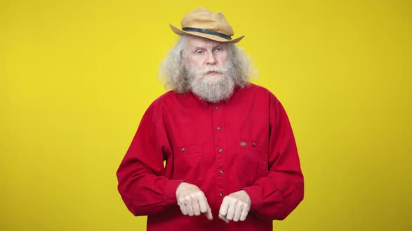 Serious Senior Caucasian Man Imitating Horse Riding at Yellow Background alt