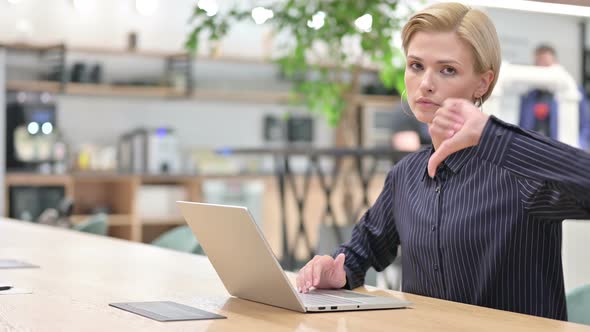 Disappointed Young Businessman with Laptop Doing Thumbs Down alt