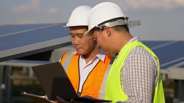 Two engineers are discussing during working at solar farm alt