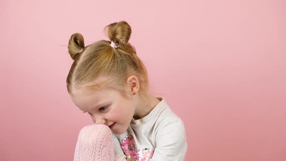 Sad Little Blonde Girl on Pink Background alt