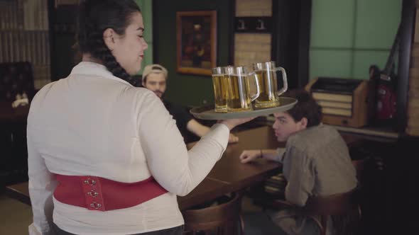 Beautiful Sweet Fat Girl with Three Glasses of Beer on a Tray in a Beer Restaurant alt