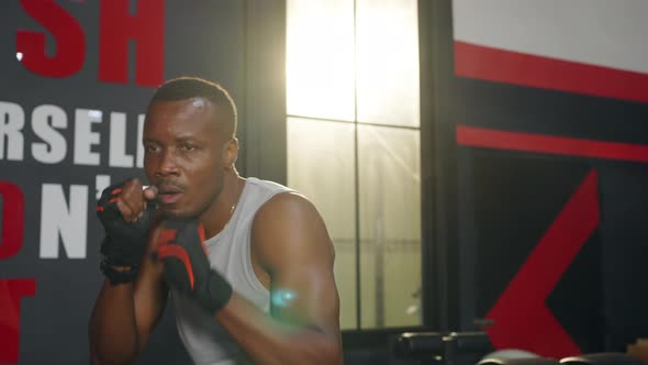 4K African man athlete do boxing exercise with punching the air at gym alt