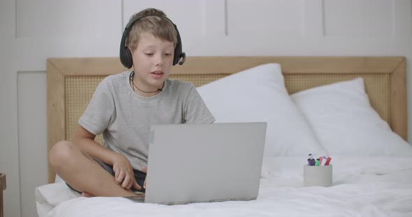 Online Communication From Home of Child Boy with Classmates or Parents By Laptop with Video Chat alt