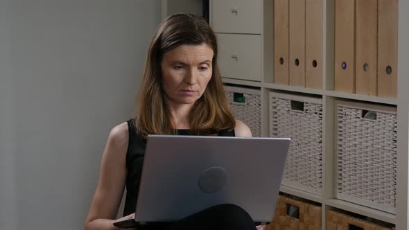 Businesswoman In Black Dress Working On Laptop At Home During Flu Quarantine