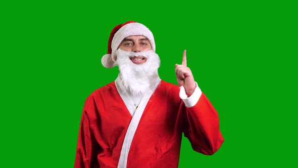 Santa Claus in Red Suit Pointing Up on Green Chroma Key Background alt