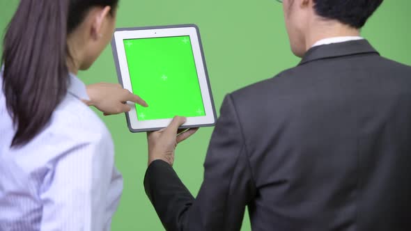 Young Asian Business Couple Using Digital Tablet Together