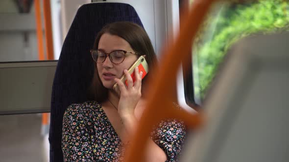 Close Shot of Young Attractive Ukraine Female in Glasses Sitting on Moving City Metro Train alt
