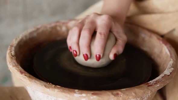 A Close Up of Hands Working on a Ceramic Piece on a Pottery Wheel in a Clay Studio alt