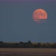 Rise of a Full Glowing Red Moon with Clouds Above the Horizon of the Earth - VideoHive Item for Sale